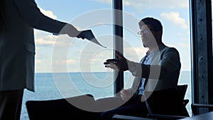 Woman giving documents ceo at sea panorama window. Pensive man waiting secretary