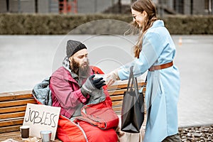 Woman giving food to a homeless beggar