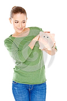 Woman giving her piggy bank a speculative look