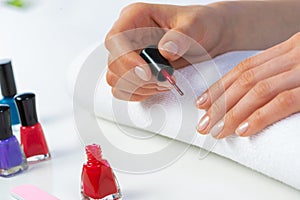 Woman giving herself elegant manicure at home