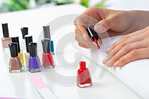 Woman giving herself elegant manicure at home