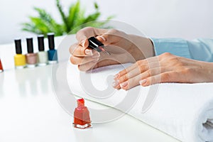 Woman giving herself elegant manicure at home