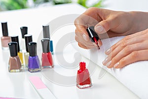 Woman giving herself elegant manicure at home