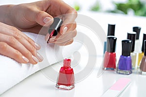 Woman giving herself elegant manicure at home