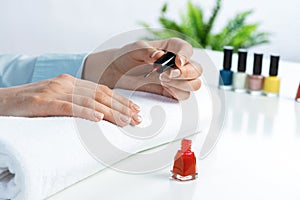 Woman giving herself elegant manicure at home