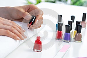 Woman giving herself elegant manicure at home