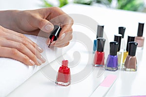 Woman giving herself elegant manicure at home