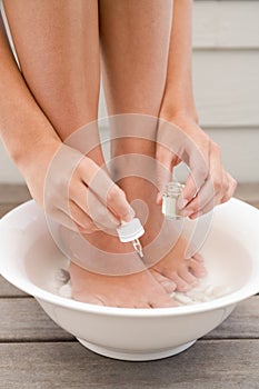 Woman giving herself pedicure