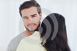 Woman giving hug to uninterested boyfriend photo