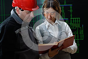 Woman is giving instructions to worker with red helmet in power