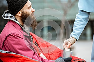 Woman giving money for a homeless beggar