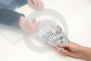 Woman giving money to teller at cash department window