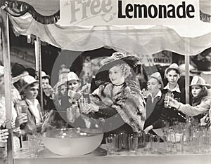 Woman giving out free lemonade to children at fair