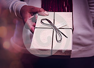 Woman giving a present for Christmas holding it in her hands