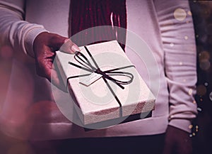 Woman giving a present for Christmas holding it in her hands