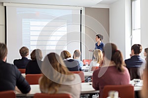 Woman giving presentation in lecture hall at university.