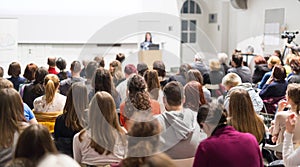 Woman giving presentation in lecture hall at university.