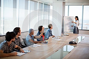 Woman giving presentation to her colleagues in conference room