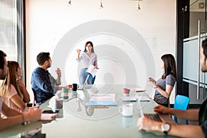 Woman giving presentation to her colleagues at office