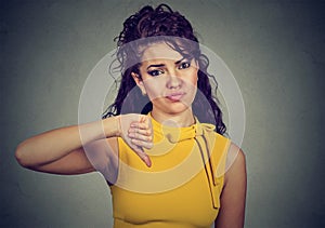 Woman giving thumb down gesture looking with negative expression