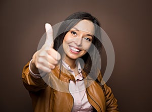 Woman giving thumbs up approval hand sign gesture smiling