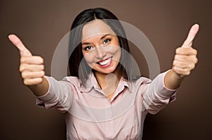 Woman giving thumbs up approval hand sign gesture smiling happy