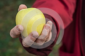 Woman giving a yellow apple