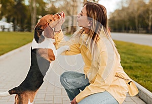 Woman giving yummy to dog in park