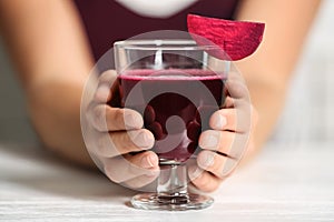 Woman with glass of beet smoothie at table