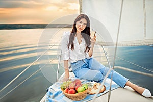 Woman with glass of champagne resting on yacht