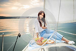 Woman with glass of champagne resting on yacht