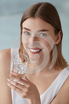 Woman with glass of fresh water in white portrait