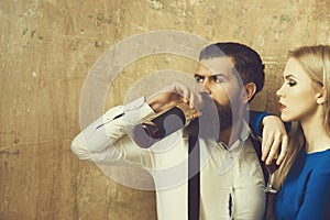 Woman with glass looking at man drinking wine from bottle