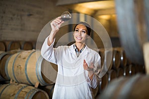 woman with glass of wine in cellar.
