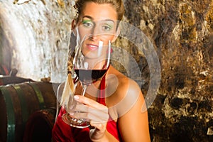 Woman with glass of wine looking skeptically