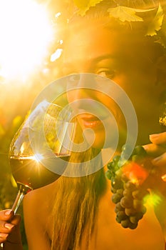 Woman with glass of wine in vineyard