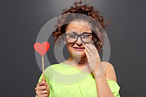 Woman in glasses with broken heart