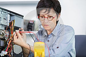 woman with glasses holding wire in hands