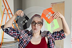 Woman in glasses holds colorful houses in her hands, color selection concept