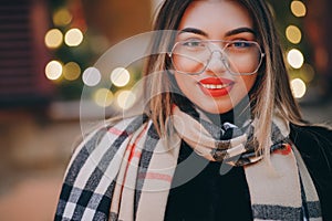 Woman with glasses look at camera poses in city center Beautiful hair attractive smile girl. Close up shot Woman with