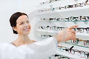 Woman with glasses and optician at optics store