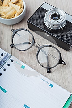 Woman glasses with planner, cookies and camera