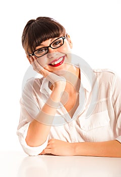 Woman in glasses and red lips, smiling at desk