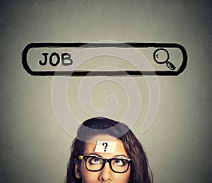 Woman in glasses thinking looking for a new job isolated on gray wall background