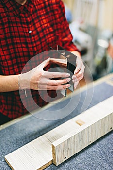 Woman glazier worker sticking together glass panes