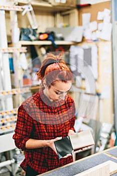 Woman glazier worker sticking together mirror glass panes