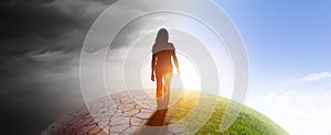 Woman on a globe from darkness into light photo