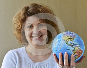 Woman with globe in hands thinking about traveling