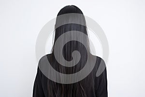 Woman with glossy brunette hair from behind, white backdrop