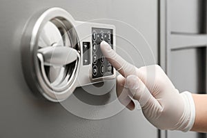 Woman in gloves entering code on keypad of safe, closeup